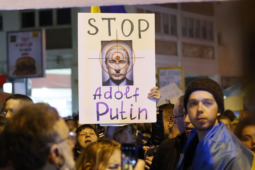 A demonstrálók plakátokat tartanak a tel-avivi orosz nagykövetség előtt, tiltakozva az invázió ellen. 