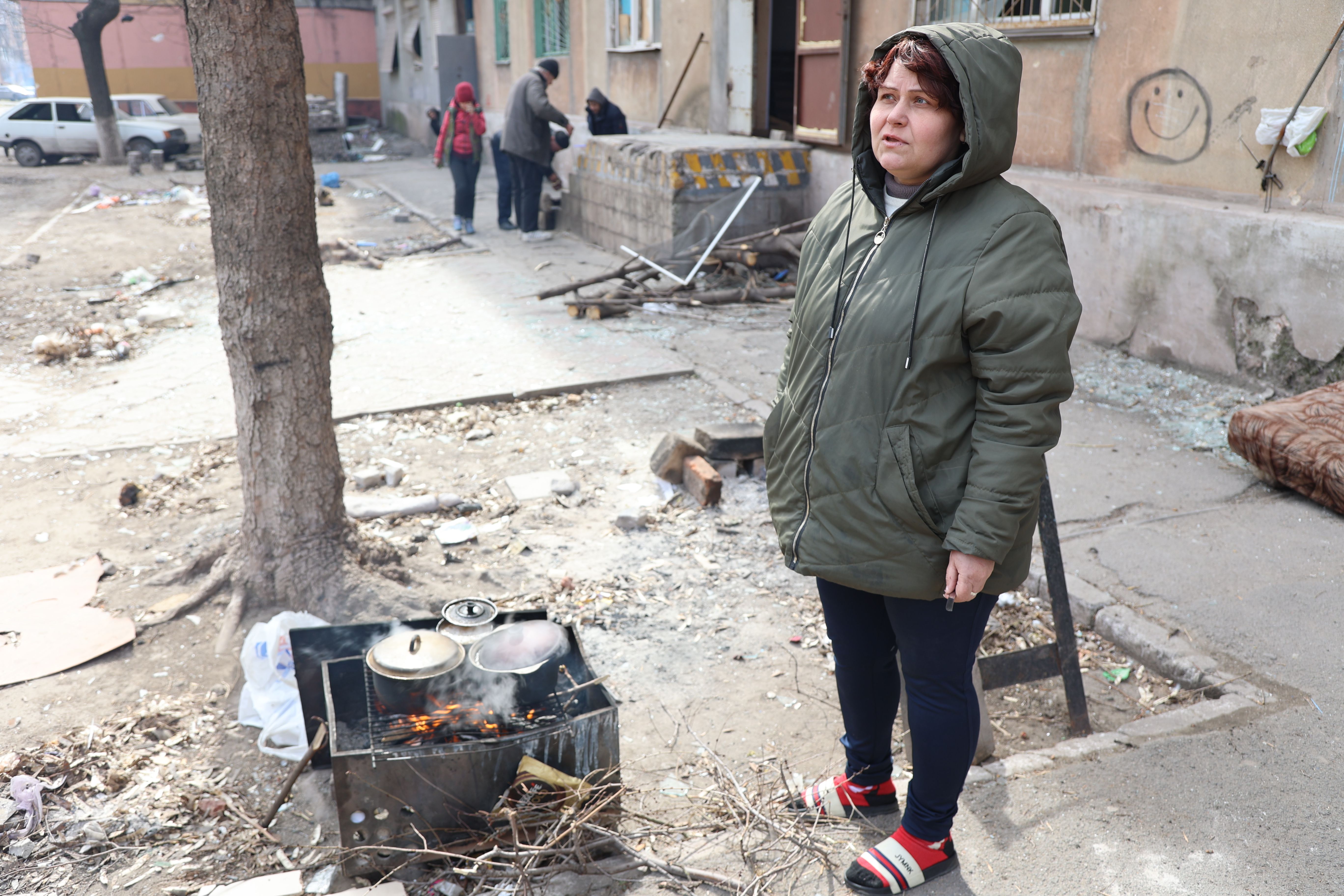Civilek ételt főznek egy lebombázott lakás romjai között az orosz hadsereg és az oroszbarát szakadárok ellenőrzése alatt álló ukrán Mariupol városában március 29-én.