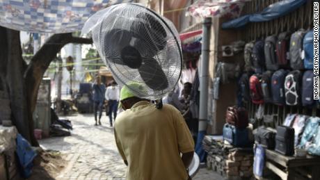 Egy férfi ventilátort tart a hőhullám idején Kolkatában, Indiában.