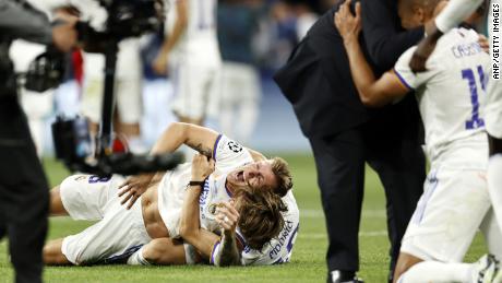 A Real Madrid játékosai a pályán ünnepelnek, amikor a játékvezető fújja a végső sípot. 