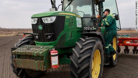 Morda Vasyl ukrán farmer belép a John Deere traktorfülkébe.