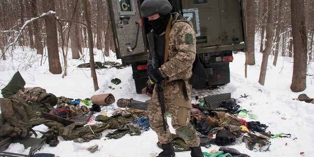 Az Ukrán Regionális Védelmi Erők önkéntese egy megsemmisült katonai járművet vizsgál meg Ukrajna második legnagyobb városa, Harkov külterületén 2022. március 7-én, hétfőn.