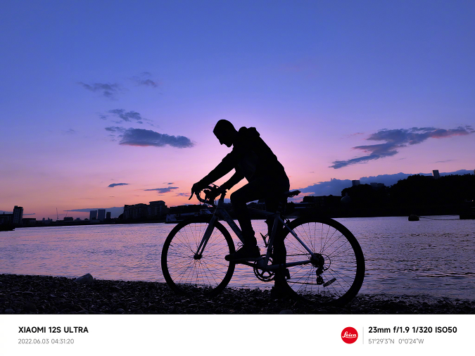 Xiaomi 12S Ultra készülékkel készült mintafelvétel, amelyen egy kerékpáros látható a folyóparton kora reggel napkelte előtt.