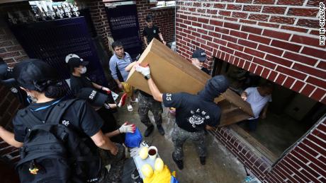 Katonák hordták ki a törmeléket egy elárasztott házból a dél-koreai Szöulban augusztus 10-én.