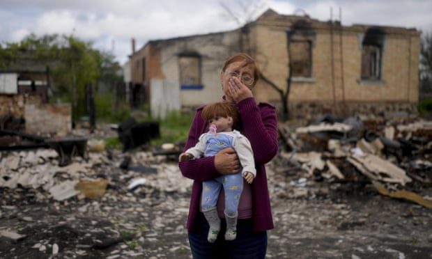 Nella Zelenska egy unokája babáját tartja lerombolt otthona előtt Potasnyában, Kijev mellett, Ukrajnában májusban.