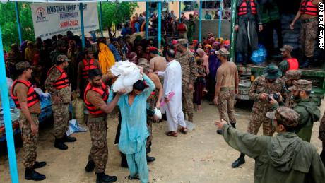 A hadsereg erői élelmiszert és készleteket osztanak szét a lakóhelyüket elhagyni kényszerült embereknek egy segélytáborban a dél-pakisztáni Jamshoro kerületben augusztus 24-én.