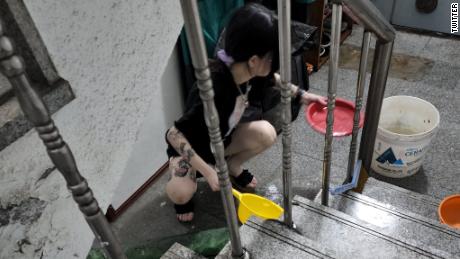 Egy nő lapátol vizet egy elárasztott alagsori lakásból a dél-koreai Szöulban augusztus 10-én.