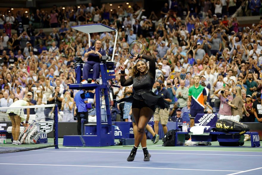 Serena Williams a tömeghez emeli ütőjét és karját, miközben a pályán áll győzelme után