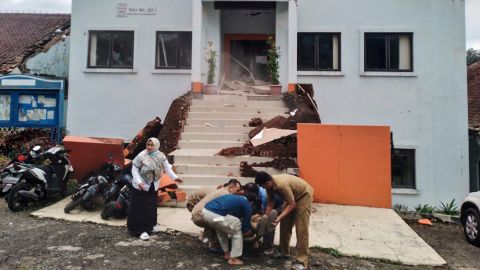 A cianjuri önkormányzati tisztek evakuálják a földrengés következtében megsérült kollégát.