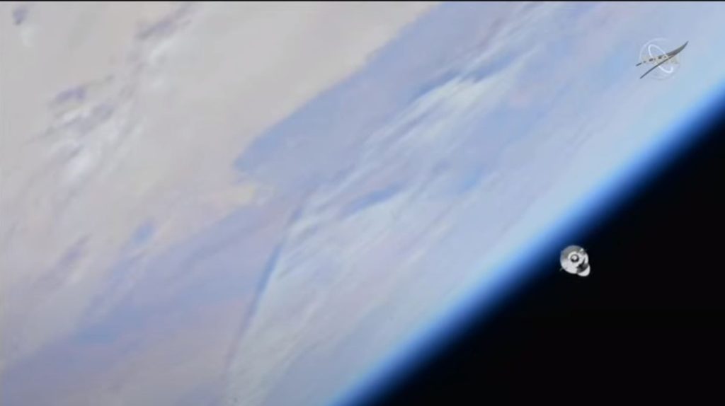 The SpaceX Dragon CRS-26 cargo ship seen in space with the blue Earth below.