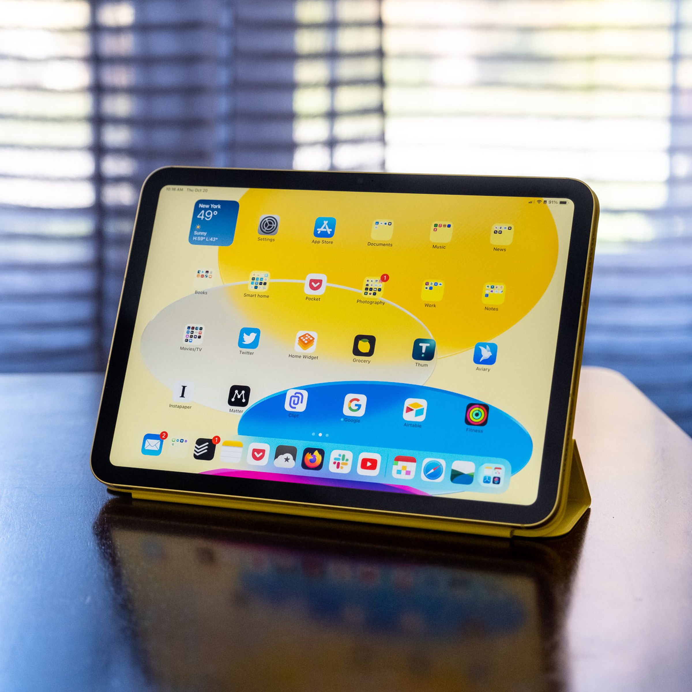 Egy 10. generációs iPad Apple Smart Folio-ban egy fából készült asztalon.