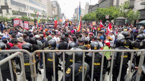 Rendőrök állnak őrt, miközben az emberek összegyűlnek a perui kongresszus előtt, miután Pedro Castillo elnök bejelentette, hogy december 7-én feloszlatja a közgyűlést.