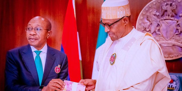 FÁJLOK: Godwin Emefele balról, a Nigériai Központi Bank (CBN) elnöke részt vesz az új bankjegyek bemutatóján, miután 2022. november 23-án Muhammadu Buhari nigériai elnök, jobbra, a hamisítás és a növekvő biztonsági problémák miatt bemutatta az újonnan tervezett bankjegyeket. Abujában, Nigériában.